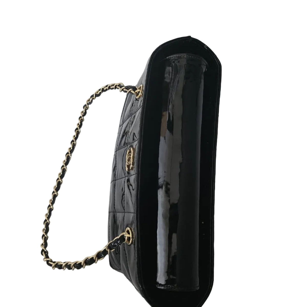 A black quilted handbag with a glossy patent leather side panel, a gold-tone chain strap, and a small gold-tone interlocking CC logo on the front, photographed on a white surface.