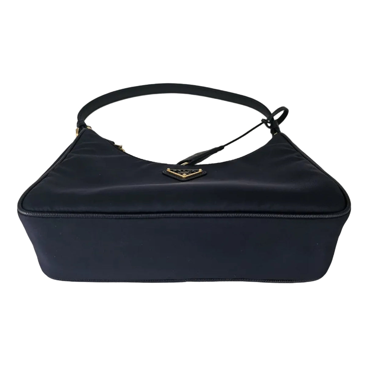 A navy blue nylon shoulder bag with a gold-tone metal logo clasp, photographed on a neutral light gray background.
